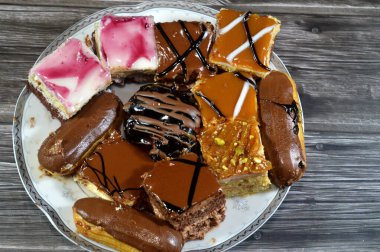 Farklı soslu çeşitli küçük Gateaux, Gateau ısırıkları, çeşitli pasta aromalı ve dolgulu, minyatür kekler, ekler, mili feille ve sünger kekten yapılmış küçük lokma büyüklüğünde pastalardır.