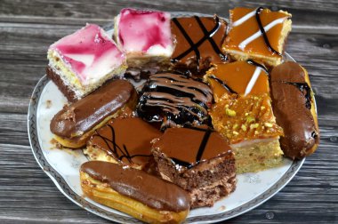 Farklı soslu çeşitli küçük Gateaux, Gateau ısırıkları, çeşitli pasta aromalı ve dolgulu, minyatür kekler, ekler, mili feille ve sünger kekten yapılmış küçük lokma büyüklüğünde pastalardır.