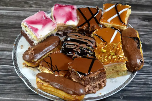 Farklı soslu çeşitli küçük Gateaux, Gateau ısırıkları, çeşitli pasta aromalı ve dolgulu, minyatür kekler, ekler, mili feille ve sünger kekten yapılmış küçük lokma büyüklüğünde pastalardır.