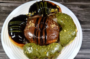 Çeşit çeşit şam fıstığı, koyu ve kahverengi çikolata, halka donutlu fındık, jöleli, mayalı, Amerikan usulü yüzük donutu, mayalanmış yağda kızartılmış hamurdan yapılan yiyecekler.