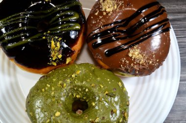 Çeşit çeşit şam fıstığı, koyu ve kahverengi çikolata, halka donutlu fındık, jöleli, mayalı, Amerikan usulü yüzük donutu, mayalanmış yağda kızartılmış hamurdan yapılan yiyecekler.