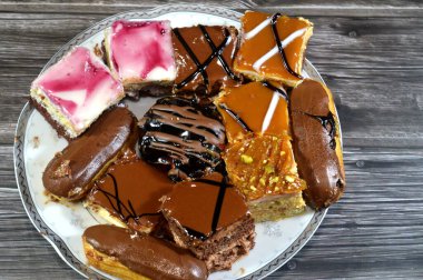 Farklı soslu çeşitli küçük Gateaux, Gateau ısırıkları, çeşitli pasta aromalı ve dolgulu, minyatür kekler, ekler, mili feille ve sünger kekten yapılmış küçük lokma büyüklüğünde pastalardır.