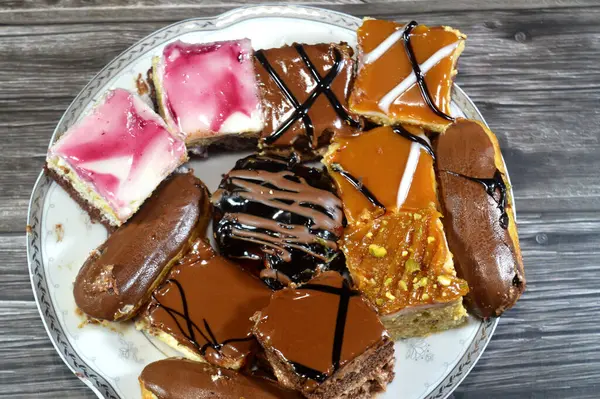 Farklı soslu çeşitli küçük Gateaux, Gateau ısırıkları, çeşitli pasta aromalı ve dolgulu, minyatür kekler, ekler, mili feille ve sünger kekten yapılmış küçük lokma büyüklüğünde pastalardır.