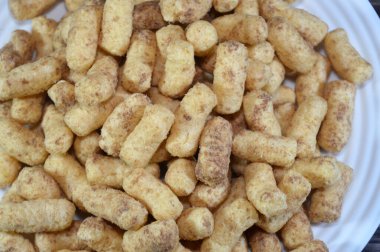 Fıstık aromalı puf, patlamış mısır ya da mısır gevreği, mısır ezmesi, pirinç, buğday ya da diğer mısır gevreğinden yapılan veya kızartılabilen mısır yemeğinden yapılan mısır gevrekleri şişirilir ya da çıkarılır.