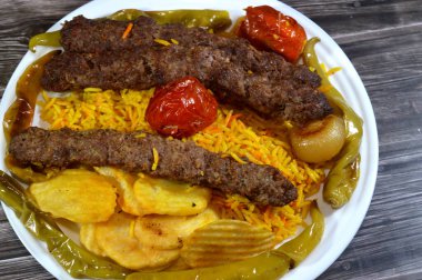 Geleneksel gıda bifteği Kofta, közlenmiş et kömürü, ızgara Arap yemeği, Sarı Basmati Hint pilavı, domatesli, soğanlı, yeşil biberli ve kızarmış patates cipsi.