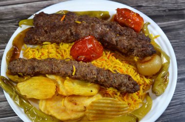Geleneksel gıda bifteği Kofta, közlenmiş et kömürü, ızgara Arap yemeği, Sarı Basmati Hint pilavı, domatesli, soğanlı, yeşil biberli ve kızarmış patates cipsi.