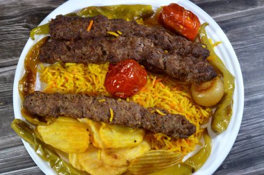 Geleneksel gıda bifteği Kofta, közlenmiş et kömürü, ızgara Arap yemeği, Sarı Basmati Hint pilavı, domatesli, soğanlı, yeşil biberli ve kızarmış patates cipsi.