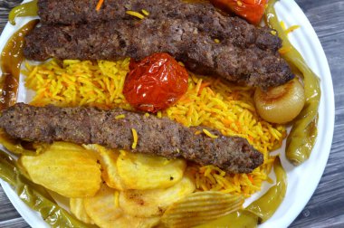 Geleneksel gıda bifteği Kofta, közlenmiş et kömürü, ızgara Arap yemeği, Sarı Basmati Hint pilavı, domatesli, soğanlı, yeşil biberli ve kızarmış patates cipsi.