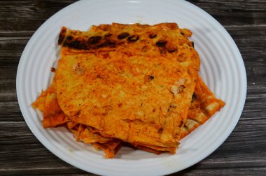 Katlanmış ince tortilla ekmeği bir tavada, ince, dairesel mayasız bir ekmek, masadan yapılmış ve buğday unundan yapılmış, pita düz ekmek tostu, öğünlerin yanında atıştırmalık olarak servis ediliyor.