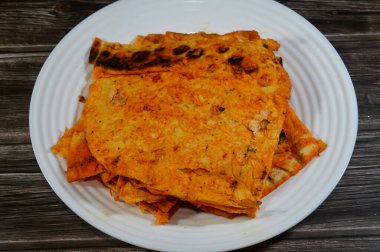 Katlanmış ince tortilla ekmeği bir tavada, ince, dairesel mayasız bir ekmek, masadan yapılmış ve buğday unundan yapılmış, pita düz ekmek tostu, öğünlerin yanında atıştırmalık olarak servis ediliyor.