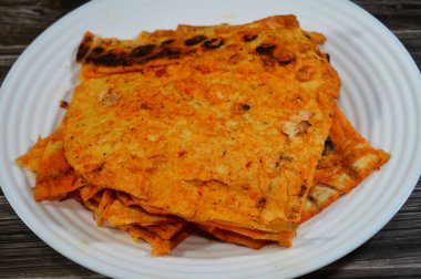Katlanmış ince tortilla ekmeği bir tavada, ince, dairesel mayasız bir ekmek, masadan yapılmış ve buğday unundan yapılmış, pita düz ekmek tostu, öğünlerin yanında atıştırmalık olarak servis ediliyor.