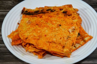 Katlanmış ince tortilla ekmeği bir tavada, ince, dairesel mayasız bir ekmek, masadan yapılmış ve buğday unundan yapılmış, pita düz ekmek tostu, öğünlerin yanında atıştırmalık olarak servis ediliyor.