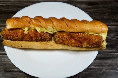 Ekmeğe sarılmış iki parça tavuk mozarella, patates, mayonez ve lahana salatası, tavuklu sandviç.