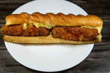 Ekmeğe sarılmış iki parça tavuk mozarella, patates, mayonez ve lahana salatası, tavuklu sandviç.