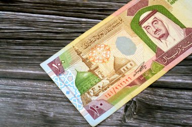 100 SAR 'ın karşı tarafında 100 Suudi Arabistan vatandaşı nakit para banknotu, Kral Fahd Bin AbdulAziz' in ve peygamberin Madina şehrindeki camiinin bir portresi yer alıyor.
