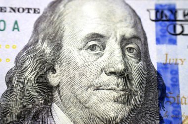 Benjamin Franklin 'in yüz dolar nakit para banknotunun ters tarafında duran portresi aynı zamanda arka planda bir tüy ile Bağımsızlık Bildirgesi yer almaktadır.