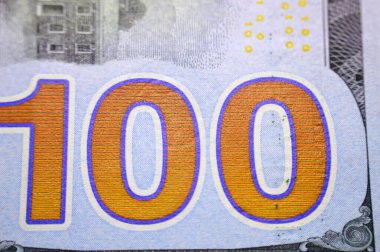 100 $'ın tersinden gelen büyük turuncu banknot 100 $nakit para banknotu, ters tarafta Philadelphia, Pennsylvania' daki Independence Hall yer almaktadır.
