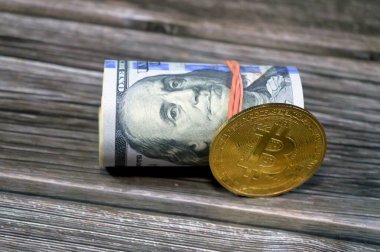Bitcoin BTC fiziksel altın sikke ve 100 dolar 100 Amerikan doları nakit para banknotları lastik bant ile sarılı, Benjamin Franklin, Amerikan para durumu konsepti