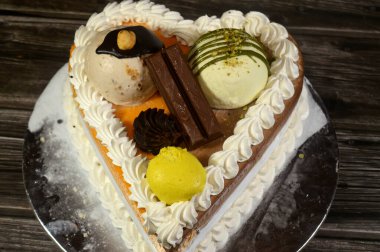 Dondurma, çeşitli aromalı ve içinde kek katmanı olan dondurmalı pasta, dondurma, mango, vanilya ve çikolata, şam fıstığı topu ve sos ve fındık topu.