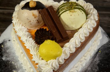 Dondurma, çeşitli aromalı ve içinde kek katmanı olan dondurmalı pasta, dondurma, mango, vanilya ve çikolata, şam fıstığı topu ve sos ve fındık topu.