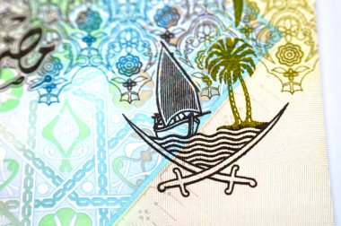 Katar Riyal nakit para biriminin 1 Katar Riyal 'ın ters tarafının bir parçası. Katar banknotunun para birimi. Sütun, kemer, yelkenli, palmiye ağaçları, çapraz kılıçlar, antika eski Katar faturası.