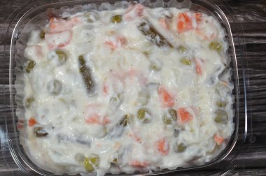 Basit Rus salatası, Olivier salatası, kremalı mayonez sosuna bulanmış patatesler, havuçlar ve bezelyeler, bütün sebzeler yumuşayana kadar pişirilir ama lapa olmaz, sonra karıştırılır.