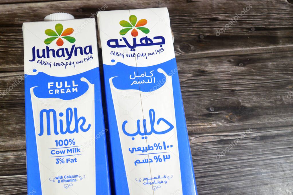Cairo, Egypt, October 2 2025: Juhayna full cream fresh cow's milk carton bottle of 1 Liter litres with Calcium and vitamins, selective focus of Johayna natural milk on wooden background