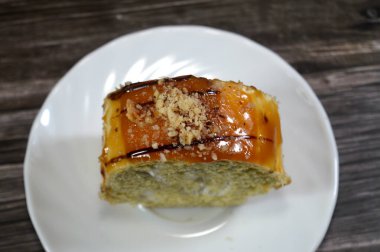 İsviçre usulü bir pasta dilimi, jöleli pasta, kremalı sarı ya da açık kahverengi bir sünger, ve üstüne fındık serpiştirilmiş karamel jöle, bir sünger İsviçre dürümü gateaux.