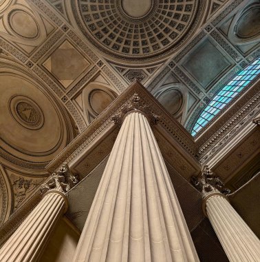 Pantheon, Paris 'te büyük bir mimari alanın iç görünümü, dekoratif Korint başkenti olan flütlü bir sütun, geometrik desenli süslü bir tavan ve katmanlı tasarımı olan büyük bir merkez kubbe.