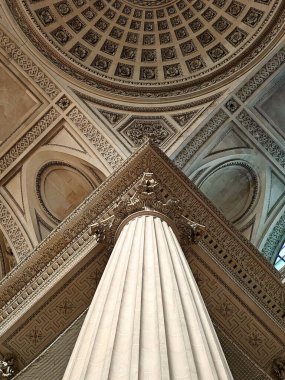 Pantheon, Paris 'te büyük bir mimari alanın iç görünümü, dekoratif Korint başkenti olan flütlü bir sütun, geometrik desenli süslü bir tavan ve katmanlı tasarımı olan büyük bir merkez kubbe.