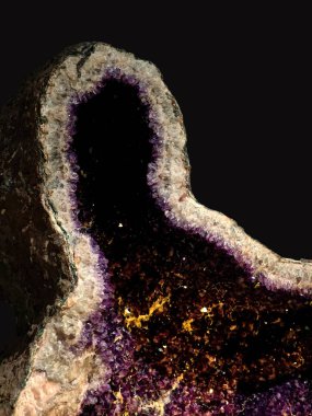 Koyu arkaplanda ametist kuvars kristalleri olan bir jeotun yakın plan görüntüsü.