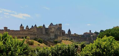 Carcassonne Güçlendirilmiş Şehir, Fransa 'da geniş duvarları ve kuleleri olan bir ortaçağ kalesi, yeşilliklerle çevrili.