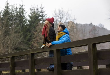 Adam ve kızı sonbaharda dağda yürüyor, kış zamanı, ulusal parkta kuşları gözlemliyorlar. Ebeveynlik. Babam çocuklarla vakit geçiriyor. Her ikisi de kalın kıyafetler giyiyor: ceket, şapka, eşarp. Duygusal açıdan iyi.