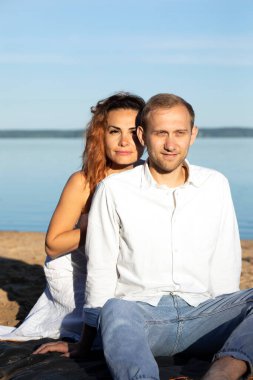 Mutlu uluslararası çift sahilde yatıyor. Latin kadın, beyaz adam tatilin tadını çıkarıyor. Gülümseyen kadın, erkek başka tarafa bakıyor. Romantik bir gezi, adada balayını kutlamak. İnsanlar dikey giyinir.