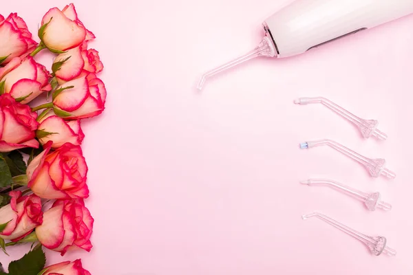 Uluslararası Diş Hekimleri Günü 'nüz kutlu olsun gül çiçekleri, diş temizleyicisi, pembe arka planda diş fırçası. Profesyonel tatil için diş sağlığı tebrik kartı. Odaklanma alanı, merkezde metin için yatay düzlem alanı