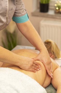 Masör, terapist şişman bir kadının sırtına profesyonel terapi masajı yapıyor. Spa salonunda müşterinin kaslarını yoğuruyor. Zihinsel, sağlık sürdürülebilirliği. Rahatlama, sağlık hizmetleri. Dikey düzlem