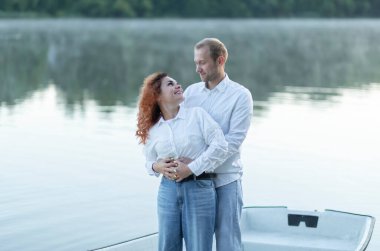 Romantik Kafkasyalı bir adam Latin bir kadına sarılıyor, çift teknede ayakta durmaktan, suda yelken açmaktan, birbirine bakmaktan hoşlanıyor. Mutlu gülümseyen aşıklar günlük kıyafetler giyerler. Sevgililer Günü 'nü kutluyoruz, peri randevusu.