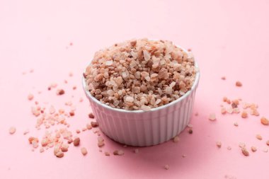 Pembe Himalaya Kaya Tuzu, Halite in White Seramik Bowl, Pembe Arkaplanda Dağıtıldı. Üst Görünüm Yatay Düzlem, Metin için Boşluğu Kopyala. Yüksek kalite fotoğraf.