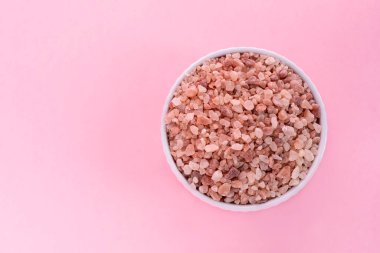 Mockup Pembe Himalaya kaya tuzu, Halite in White Seramic Bowl on Pembe Arkaplan. Üst Görünüm Yatay Düzlem, Metin için Boşluğu Kopyala. Yüksek kalite fotoğraf.