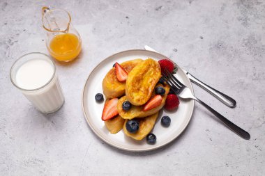 Torrijas, İspanyol usulü Fransız tostu portakal soslu, jöleli, taze yabanmersinli, yeşil tabakta çilekli, ahşap masalı. Yarım portakal. İspanyol Tatlısı. Yatay düzlem.