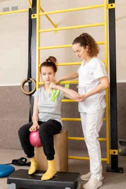 Engelli çocuk ve doktor rehabilitasyon odasında fiziksel egzersiz yapıyorlar. Özel ihtiyaçları olan çocuk. Rehabilitasyon. Beyin felci geçirmiş. Motor Bozukluk. Dikey düzlem. Yüksek kalite fotoğraf