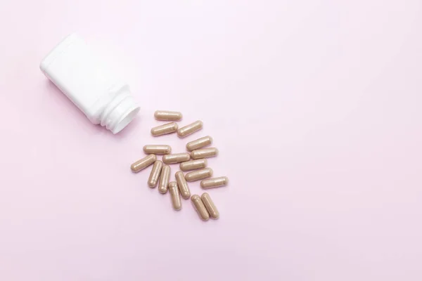 Szétszórt Tabletták Csúszós Szilfa Kapszulák Fehér Palack Rózsaszín Hátterű Tartály — Stock Fotó
