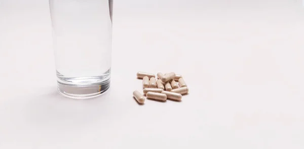 Szoros Tabletták Csúszós Szilfa Kapszulák Egy Pohár Víz Asztalon Táplálkozás — Stock Fotó