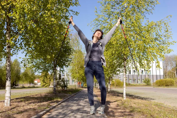 stock image Nordic walking. Happy Caucasian Woman Training In Park, Forest With Walking Sticks, Raised Hands. Physical Activity With Walking Poles . Sports Tourism, Outdoor Recreation. Horizontal Plane.