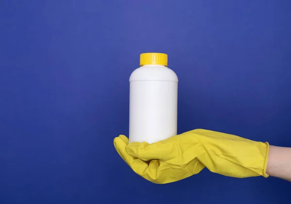 人的手在黄色手套保持白色瓶与管道清洁剂 用特殊化学品去除沉淀池 淋浴器中的堵塞 清洗厨房 浴室的牛栏 Blue Background Copyspace — 图库照片