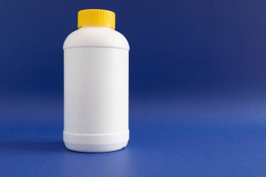 Sarı başlıklı Granüller Açılıyor, Mor Arkaplanda Beyaz Plastik Şişe. Asit temizleyicisi, ev işi yardım. Yatay Düzlem, Metin için Boşluğu Kopyala.