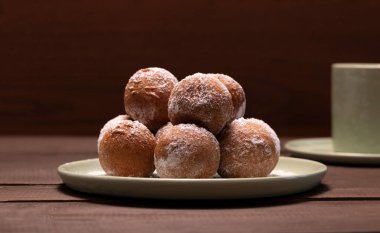Şişman Perşembe Karnavalı ya da Tlusty Czwartek, Hıristiyan geleneği. Şeker Donutu, Zeppole ya da Paczki tabakta, Kupa da arka planda. Tahta masadaki lezzetli çörekler. Yatay Düzlem