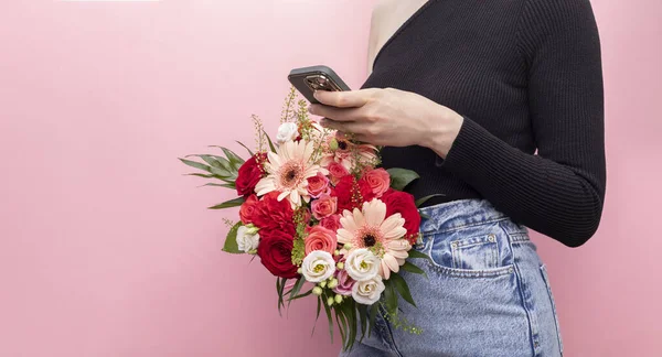 Pembe Arkaplandaki Akıllı Telefon Uygulamalarını kullanarak Taze Çiçek Buketi, Gerbera, Güller, Kasımpatı, Kasımpatı ile Genç Kafkas Tarzı Kadın Tasarımı. Çevrimiçi Düzen ve Çiçek Teslimatı Konsepti Kopyalama Boşluğu.