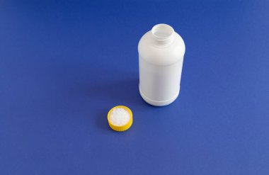 Kapalı Beyaz Plastik Şişe, Kapak Elinde Boru Temizleyici Granülleri ile Dolu. Lavabodaki tıkanıklık giderici dozajı, drenaj temizleyici tozuyla duş. Mutfakta, Banyo 'da Clog' un önünü açıyorum. Boşluğu Kopyala.