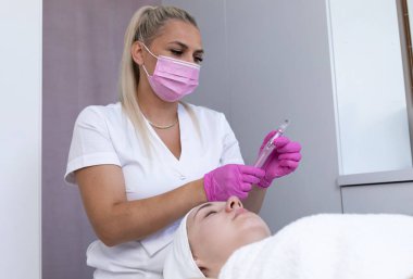 Mezoterapi ve mikro tedavi. Gerçek Kadın Güzellik Uzmanı İşgalci Kozmetik Prosedürü İçin Elektrikli Mikro Kalem Tutuyor. Mikro dermabrüksiyon, Yatay Düzlem.